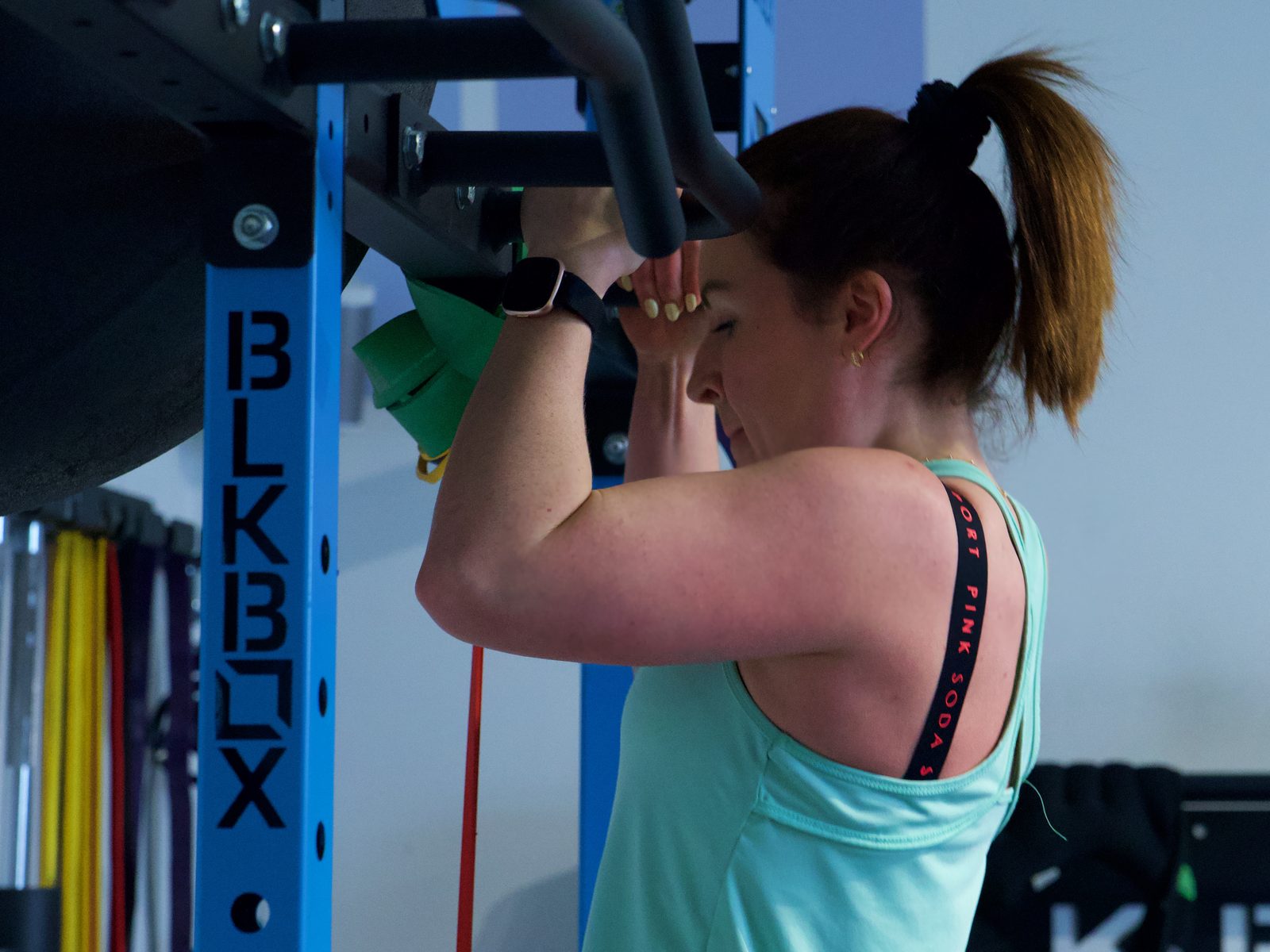 A member working through assisted chin-ups on the rig at SixFour Fitness