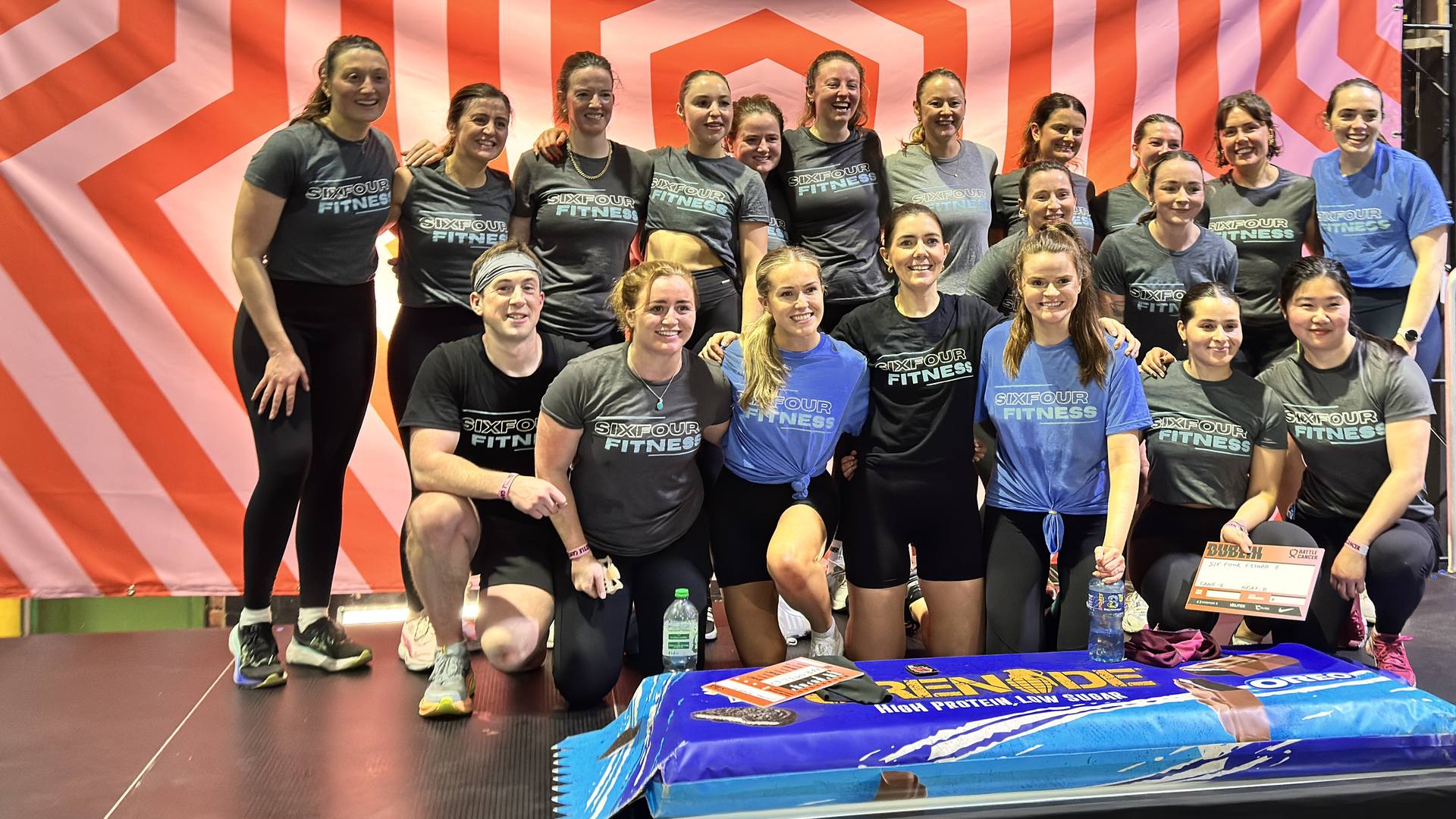 Members and coaches of SixFour Fitness together in team kit at a fitness event